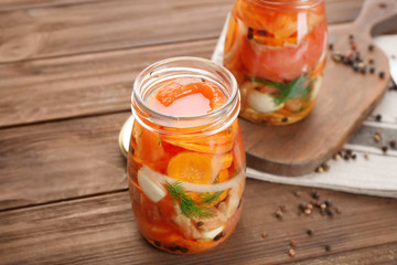 Jar with delicious marinated salmon on table