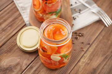 Jar with delicious marinated salmon on table