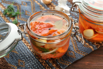 Jar with delicious marinated salmon on table