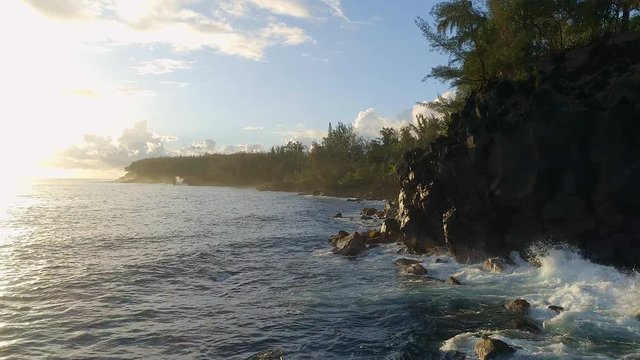 Flying Past A Rocky Coastline and Forest During a Beautiful Sunrise