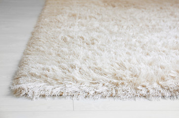 White soft carpet on wooden floor, closeup