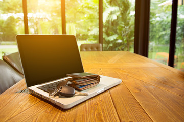 Computer Laptop on the table with wallet,key and natural background, business technology concept.