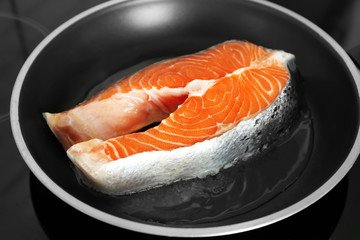 Raw salmon steak on frying pan, closeup