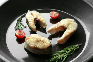 Delicious fish steaks on frying pan, closeup