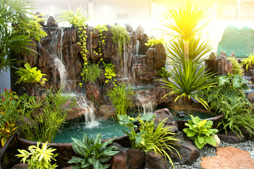 Selective focus of green forest with water fall in the department store.