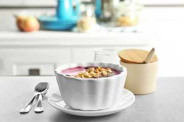 Bowl with acai smoothie and muesli on table