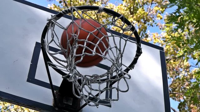 the basketball enters the basket outdoors