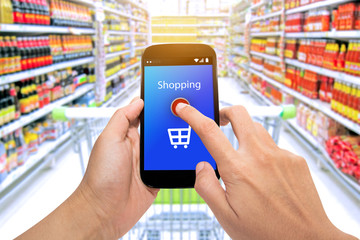 Man use mobile phone, blur image of inside supermarket background,Shopping Purchase Order Concept.