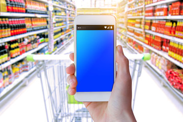 Fototapeta na wymiar Woman use mobile phone, blur image of inside supermarket background,Shopping Purchase Order Concept.
