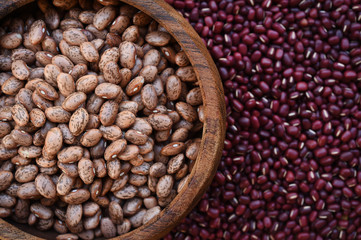 Fototapeta premium Pinto bean in wooden bowl on red bean background