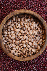 Pinto bean in wooden bowl on red bean background