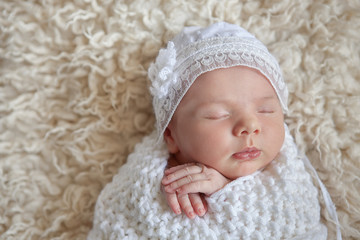 Fototapeta na wymiar Amazing newborn baby sleeping beauty enjoying first days in her his life in luxury tender clothes and blankets made by couturier