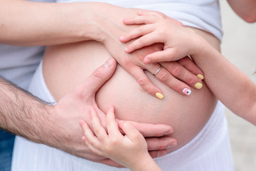 Fototapeta na wymiar Hands on the abdomen of a pregnant woman.