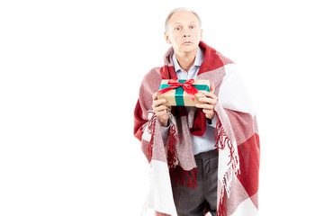 Fototapeta premium Portrait of senior man wrapped in blanket holding Christmas gift