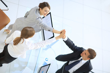 view from the top.members of the business team giving each other a high five above the Desk.