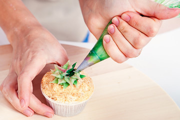 confectioner decorates  cupcake