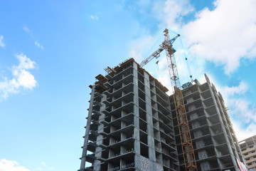 Fototapeta na wymiar Concrete residential building under construction and crane at sunny day, under view