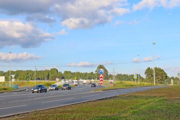 Cars and trucks move on modern highway at summer sunny day
