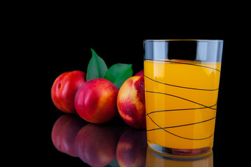 Peach juice in a glass on black background