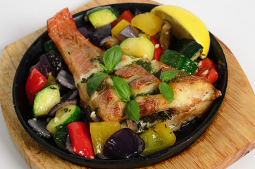 Red snapper baked with vegetables in a pan on a wooden desk