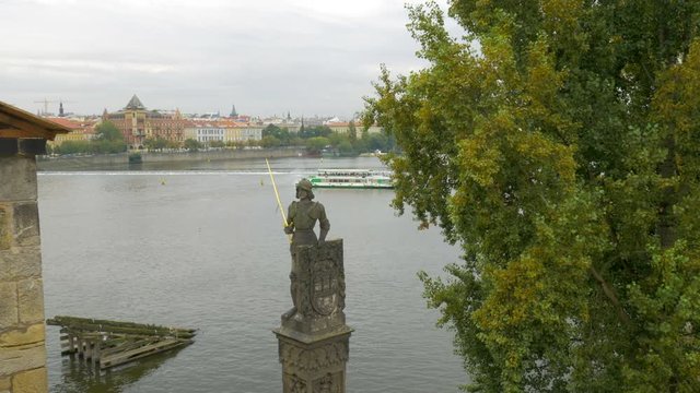 Statue of Bruncvik near  Charles Bridge in Prague. River boat turning on the background