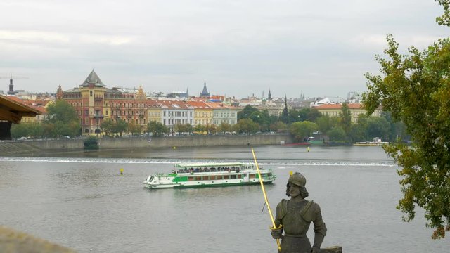 Close shot of statue of Bruncvik near  Charles Bridge in Prague. River boat passing on the background