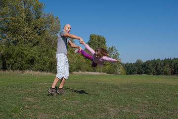 Fototapeta premium A father with daughter are playing in the park at sunny day.
