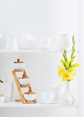 white dishvare with flowers on wooden shelf