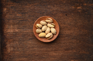 close up of pistachios in wooden bowl 