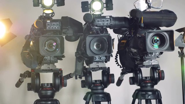 Professional video cameras on adjustable tripods. 