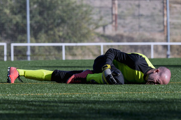 Soccer goalkeeper, lying on the floor for a sustained injury.