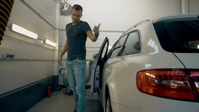Satisfied customer entering from car and showing thumbs up. Car servicing