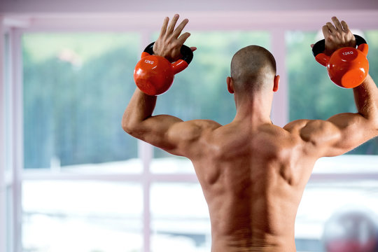 Adult guy working out using kettlebell