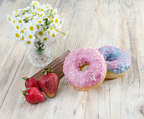 Strawberries on the table. Red strawberries on a wooden table in a glass vase. chocolate and soft buns.