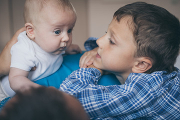 father and sons lie on the bed