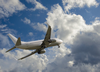 Fototapeta na wymiar Airplane flying in sky with clouds