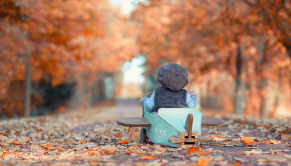 Start! - Baby im Holzflieger im Herbst
