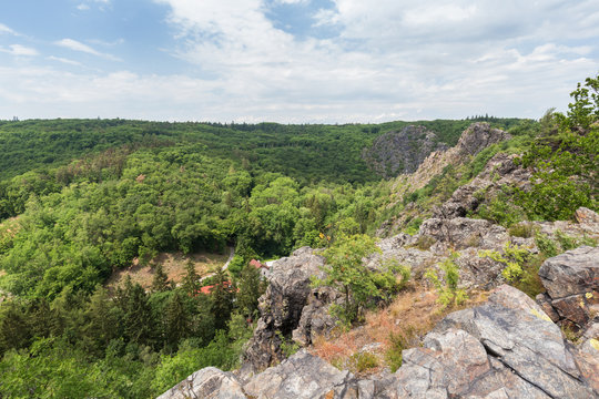 Lush gorge viewed from the rocky top at the Divoka Sarka on a sunny day. It's a nature reserve on the outskirts of Prague in Czech Republic.