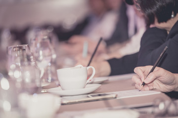 businesspeople hands with pen or pencil , papers and cups of coffee in the seminar room