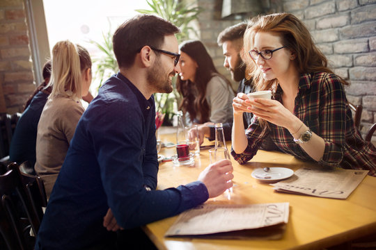Handsome man flirting with cute woman in restaurant
