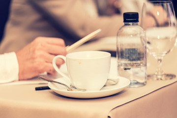 businesspeople hands with pen or pencil , papers and cups of coffee in the seminar room
