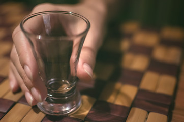 Woman holding in hands empty glass of Vodka. Party time.