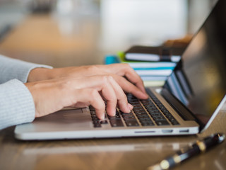 Woman hand working on her laptop with selective focus. Social networking technology concept.