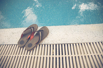 Pair of slippers beside the swimming pool