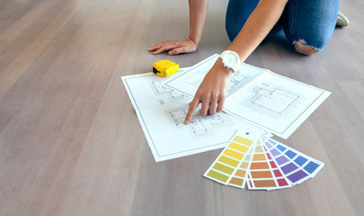 Young woman looking house plans on the floor