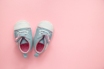 Children's denim sports shoes for girls, stands on a pink background. closeup view from the top....