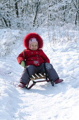 Fototapeta na wymiar Happy child on sled in winter.