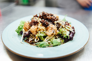 Caesar salad in a white plate on a metal surface