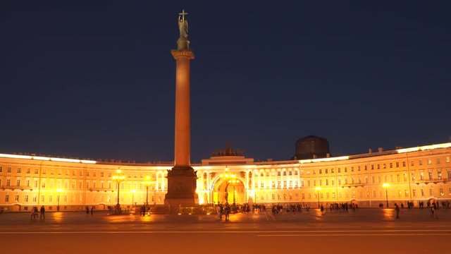 Tourists are walking along the Palace Square near the Hermitage at night St. Petersburg
