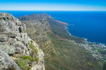 Fototapeta na wymiar Woman climbing down Table Mountain, Atlantic Ocean and Twelve Apostles peaks
